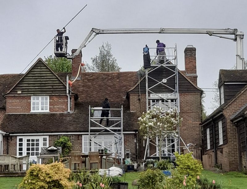 The Moss Cleaners using cherry picker and scaffolding to clean roof safely and professionally in Lymington, Hampshire